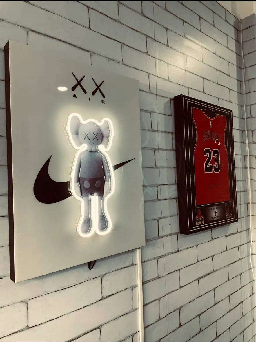 Decoración del local: cuadro neón y camiseta enmarcada